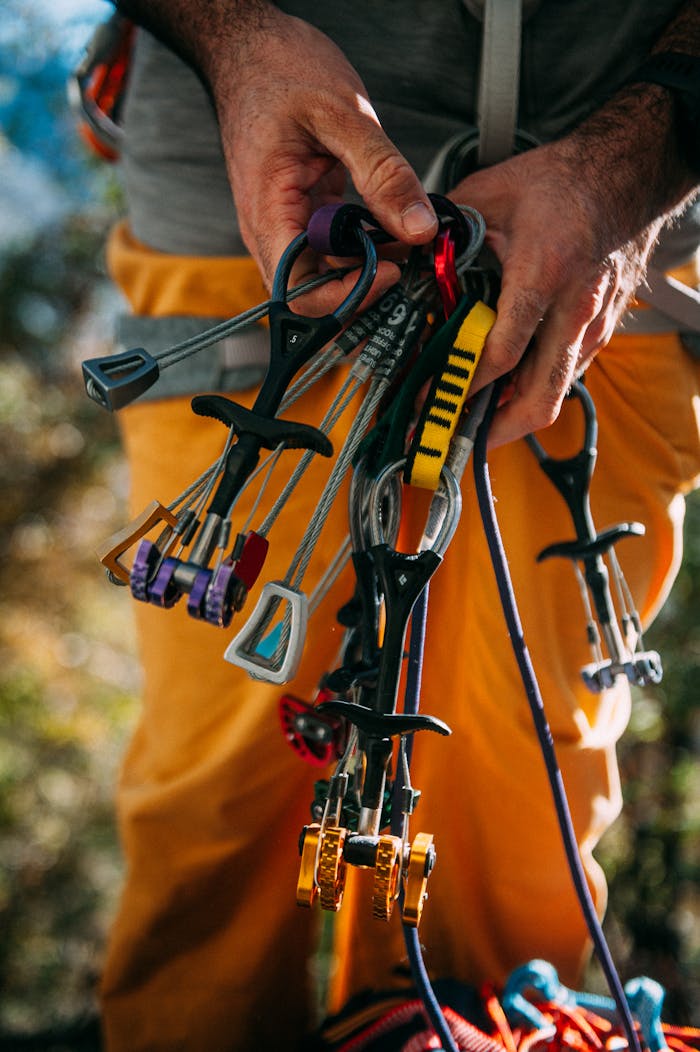 gallery-03 A detailed view of climbing tools and gear being held outdoors.