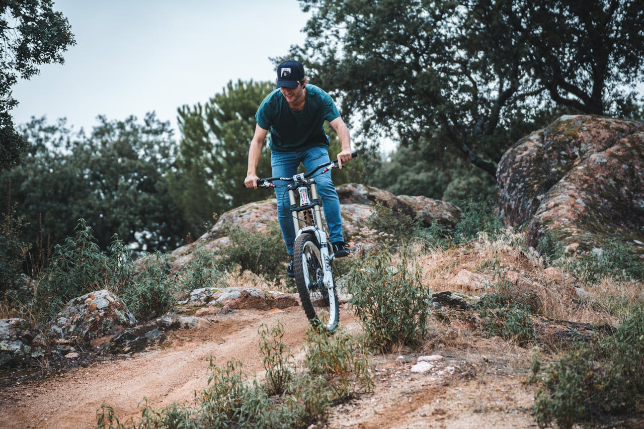 services-01 Man enjoying a thrilling mountain bike ride on a rugged trail in the outdoors.